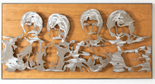 Wooden panel with hand ground metal cutouts of the Beatles in a frame. 
